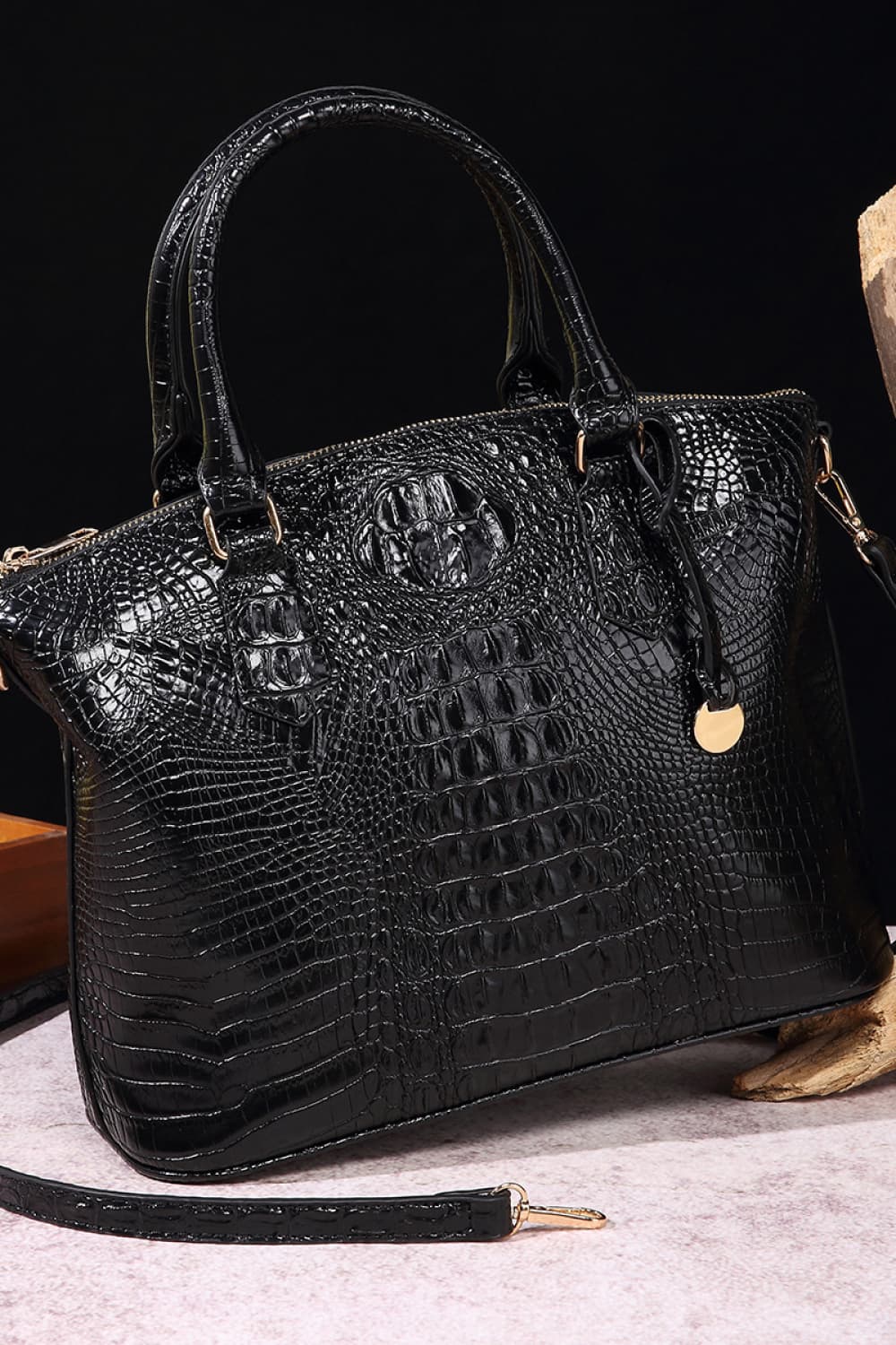 Black medium PU leather handbag with a structured silhouette, raised crocodile-embossed texture, rounded top handles, zip-top opening, and attached shoulder strap.