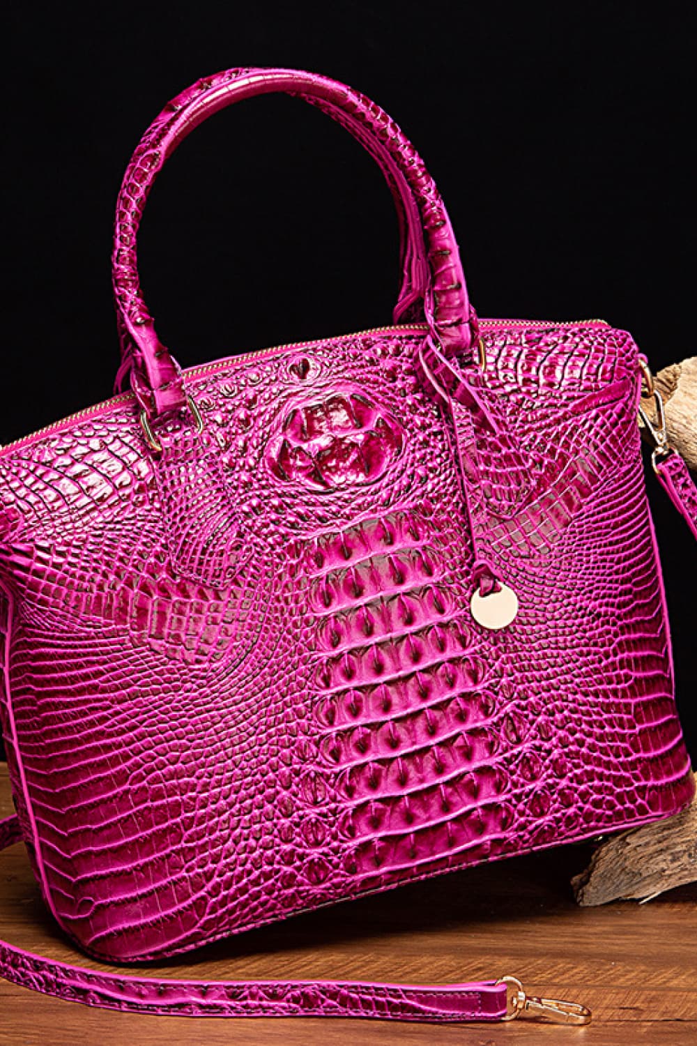 Bright fuchsia PU leather handbag with a structured, softly tapered silhouette, rounded top handles, embossed crocodile texture, zipper closure, charm, and removable strap.