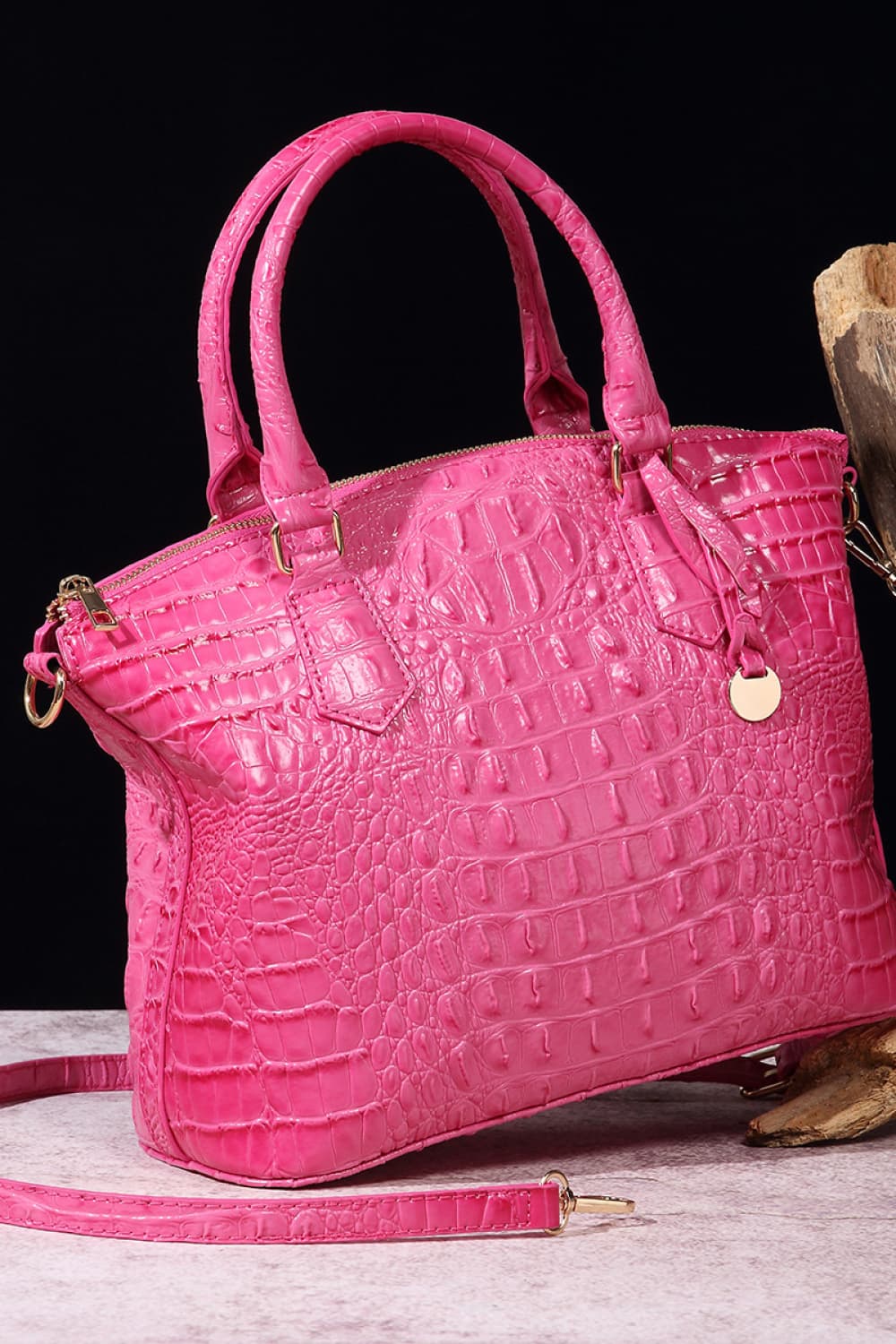 Bright pink PU leather handbag with a structured silhouette, rounded top handles, crocodile-inspired embossed texture, zip closure, removable shoulder strap, and hanging charm.