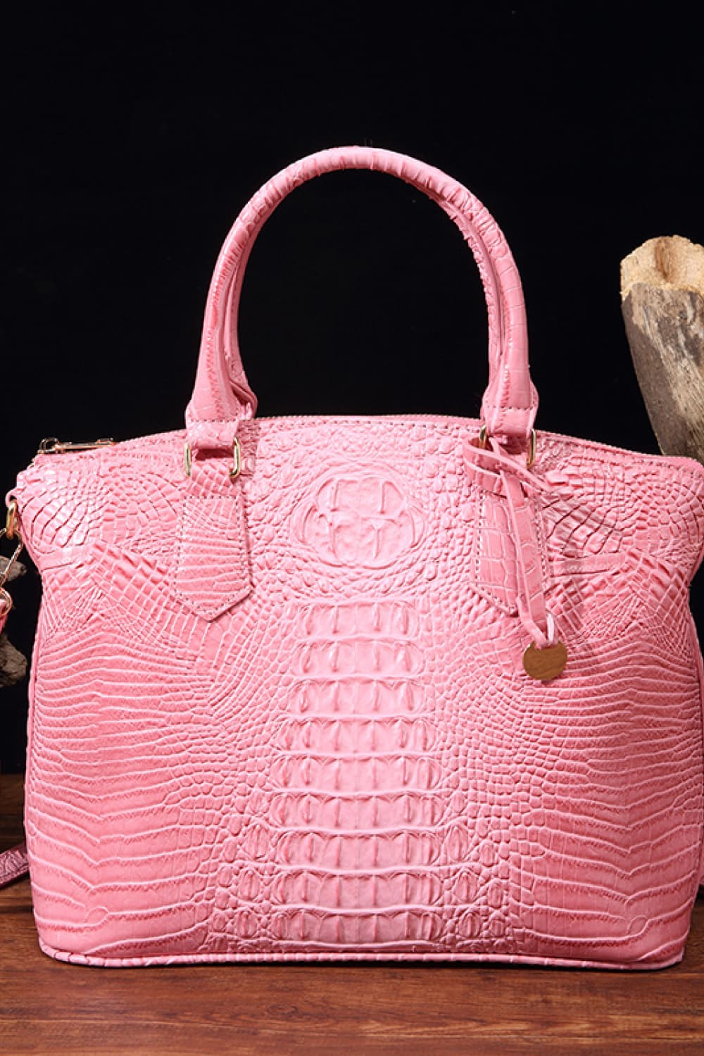 Medium pink PU leather handbag with a structured silhouette, raised crocodile-embossed texture, rounded top handles, and an attached shoulder strap.
