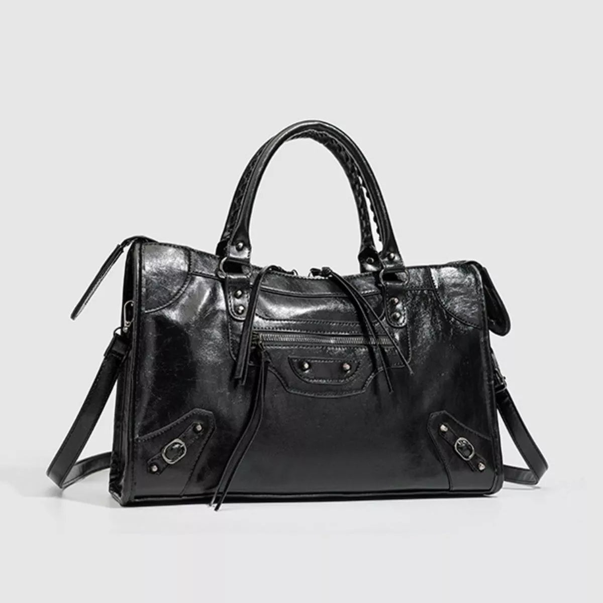 Black medium PU leather handbag with dual top handles, a structured silhouette, front zip pocket, decorative strap details, and a detachable shoulder strap.