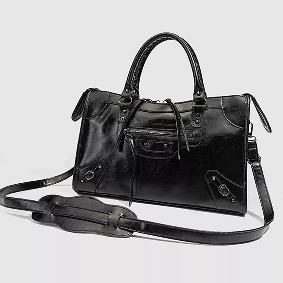 Black medium PU leather handbag with arched top handles, a structured rectangular silhouette, stitched panels, zippered front pocket, and long shoulder strap.