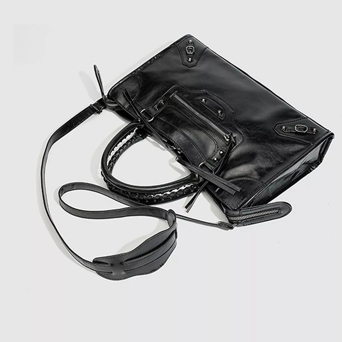 Black medium PU leather handbag with a structured silhouette, rounded top handles, long shoulder strap, and multiple exterior zip pockets.
