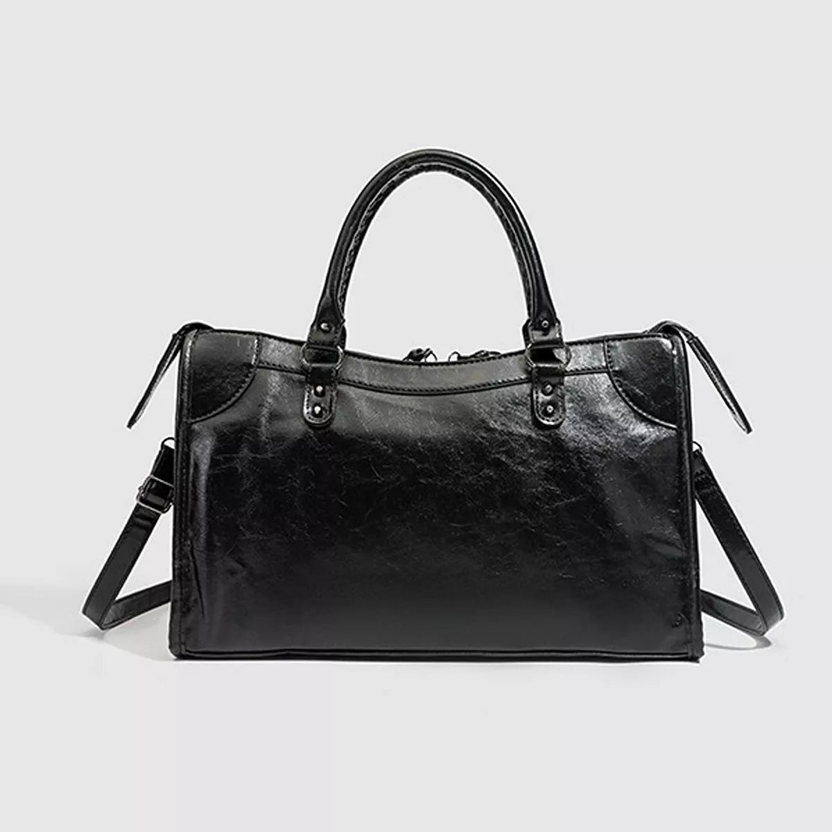 A medium black PU leather handbag with a structured rectangular silhouette, dual top handles, stitched paneling, and an attached shoulder strap.