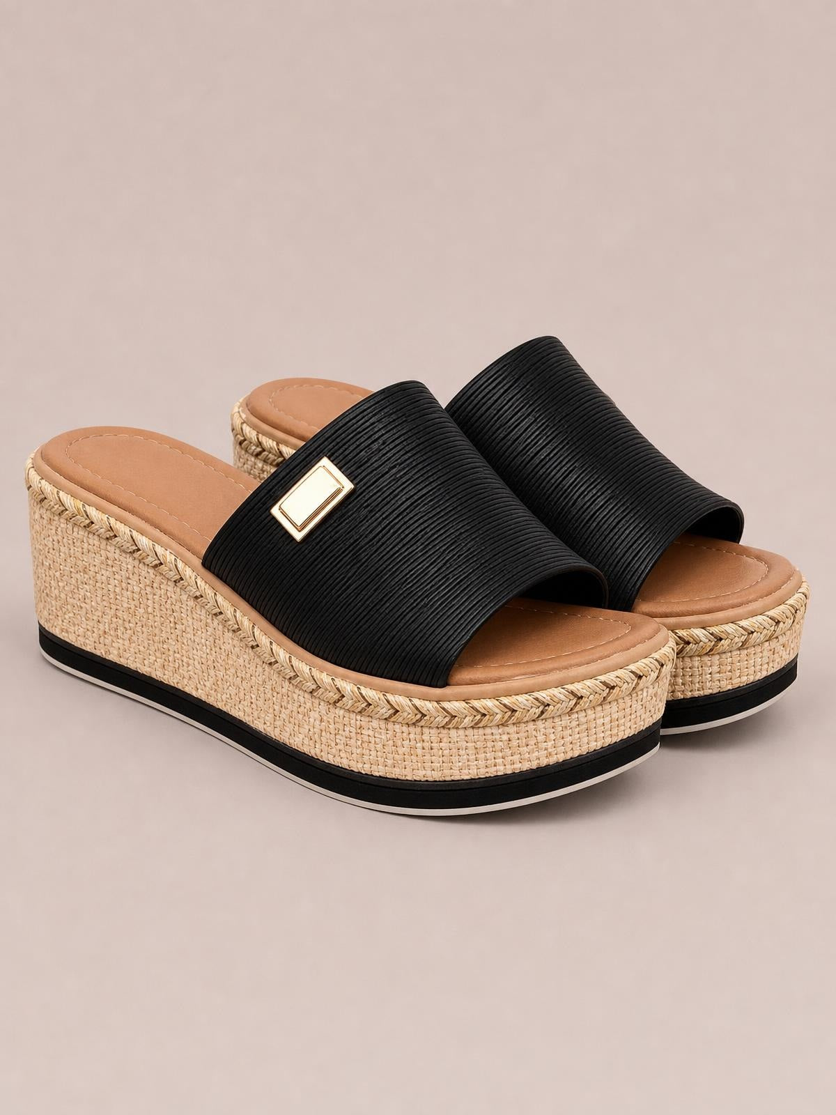 Black PU leather open-toe sandals feature wide ribbed straps, gold-tone accents, and a woven espadrille-style platform wedge with a defined sole.