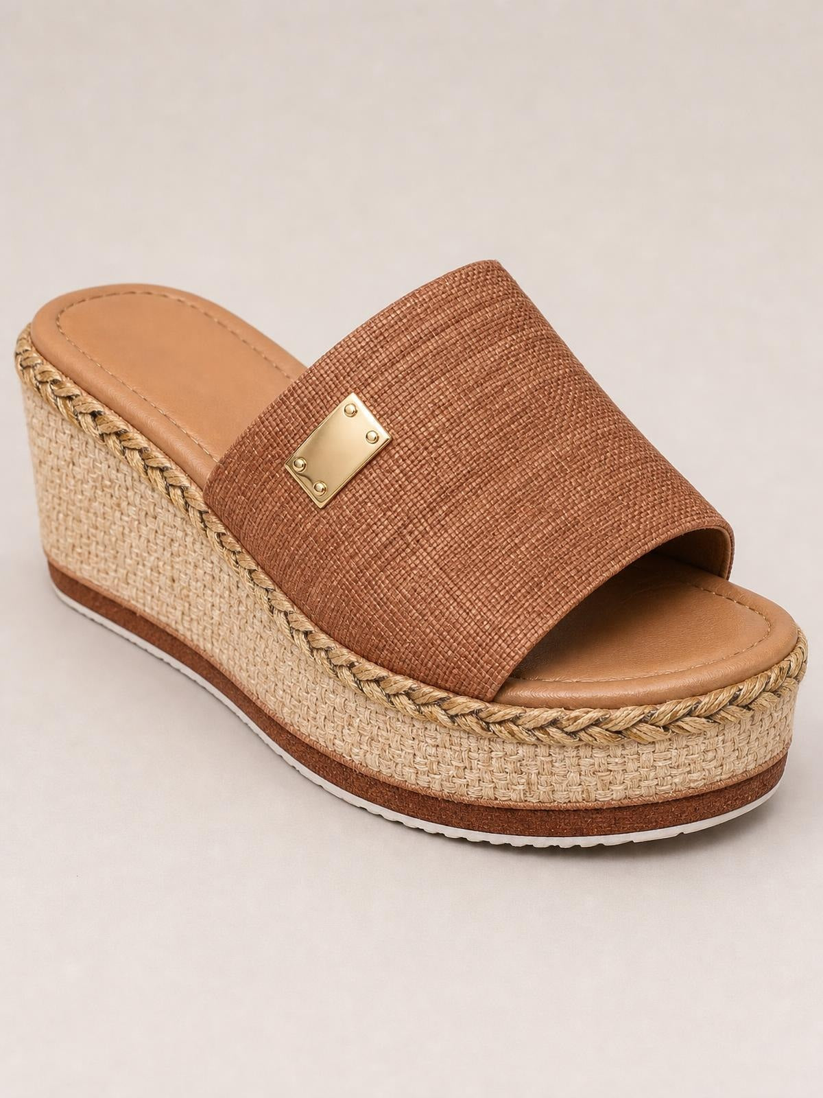 Brown PU leather open-toe sandals with a wide textured upper, gold-tone plaque, braided trim, and a mid-height woven wedge platform sole.