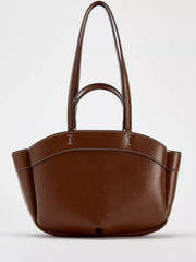 Large brown PU leather tote bag with dual top handles, a gently curved opening, side gussets, contrast stitching, and a roomy silhouette.