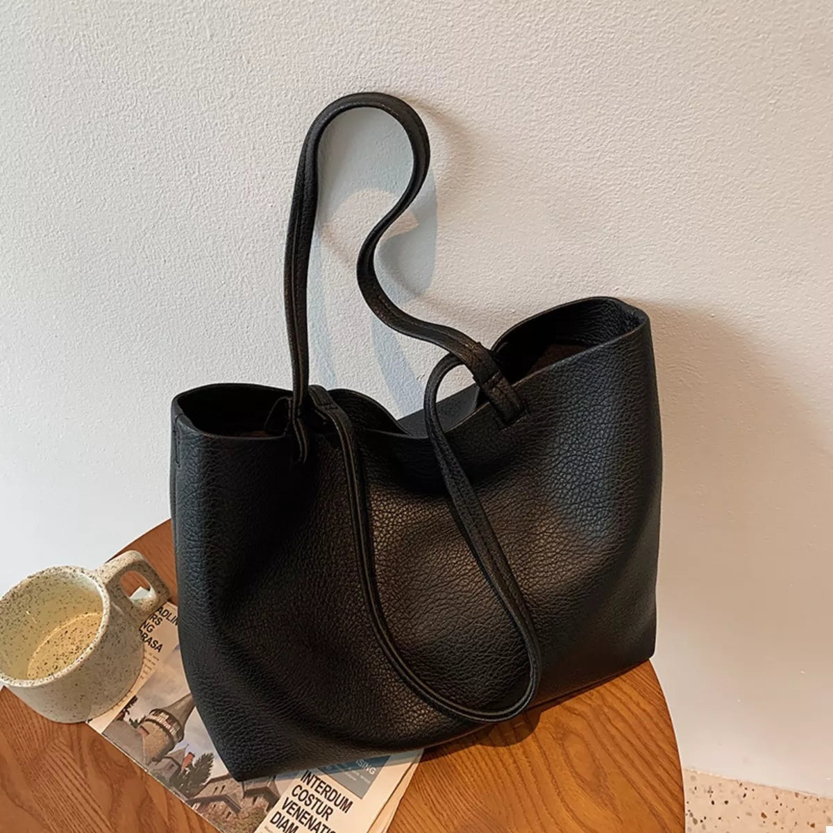 Large black PU leather tote bag with a pebbled finish, open top, long rounded shoulder handles, and a spacious slouchy silhouette.