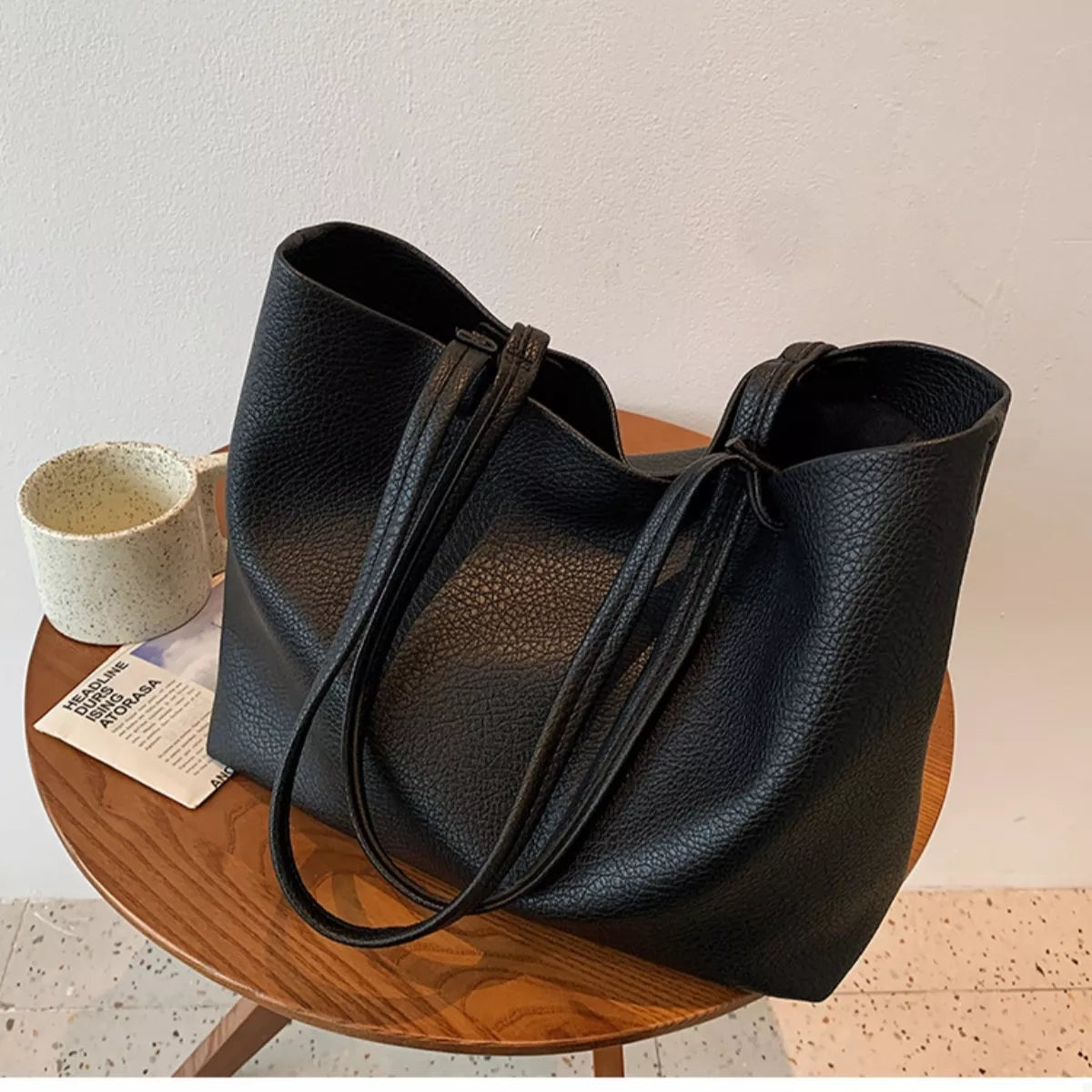Large black PU leather tote bag with a soft structured silhouette, open top, pebbled texture, and long shoulder straps.