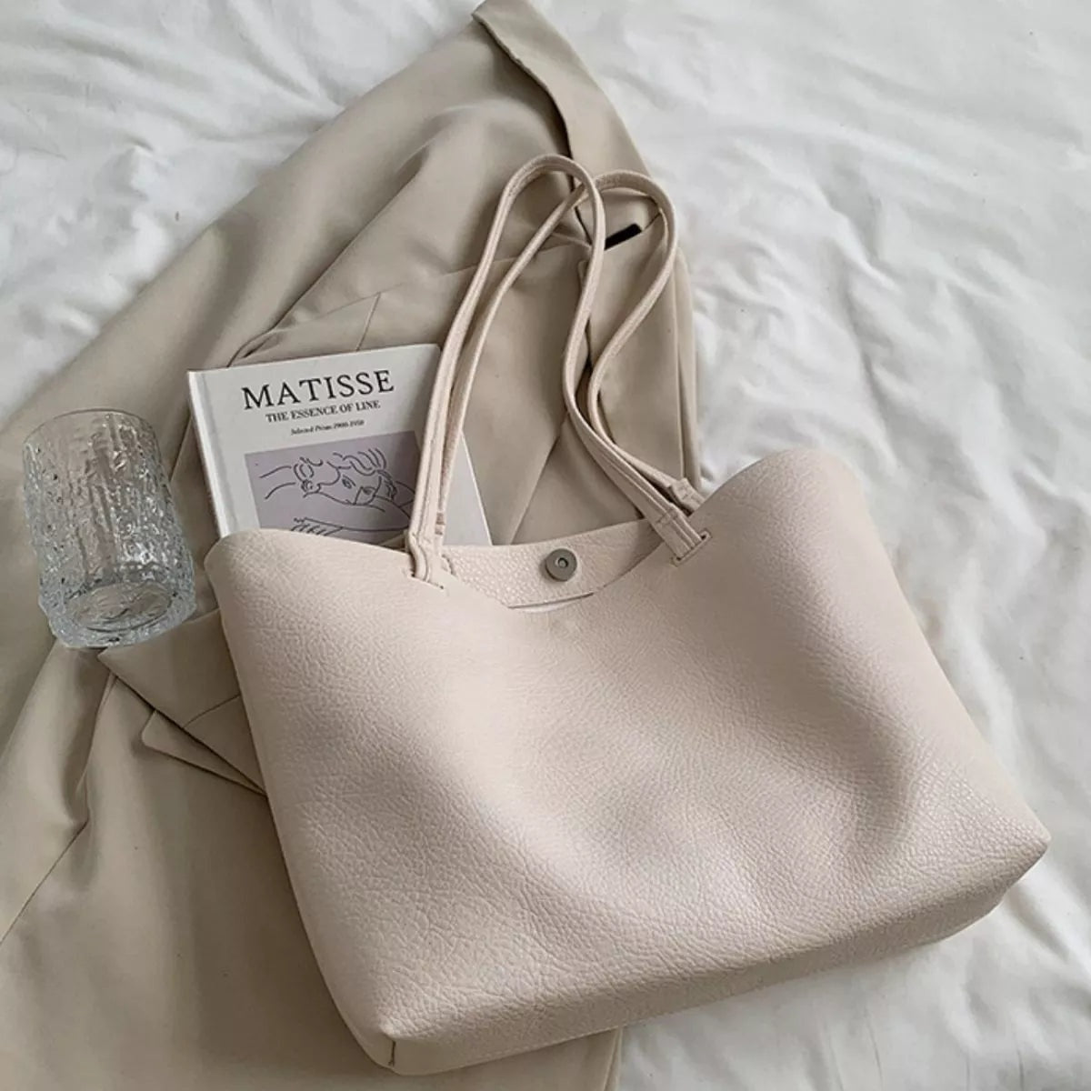 Large beige PU leather tote bag with a spacious silhouette, pebbled texture, twin shoulder straps, and a magnetic snap closure.
