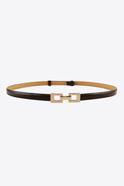 A black PU skinny belt with stitched edges, a tan backing, and a polished geometric gold-tone buckle in a slim looped silhouette.