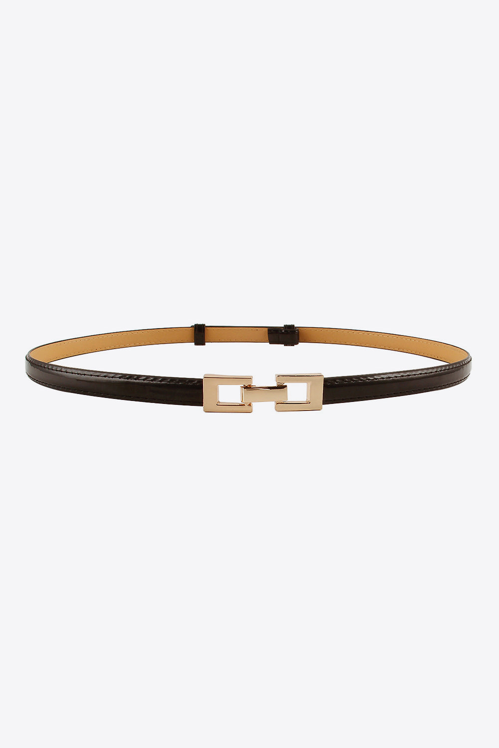 A black PU skinny belt with stitched edges, a tan backing, and a polished geometric gold-tone buckle in a slim looped silhouette.