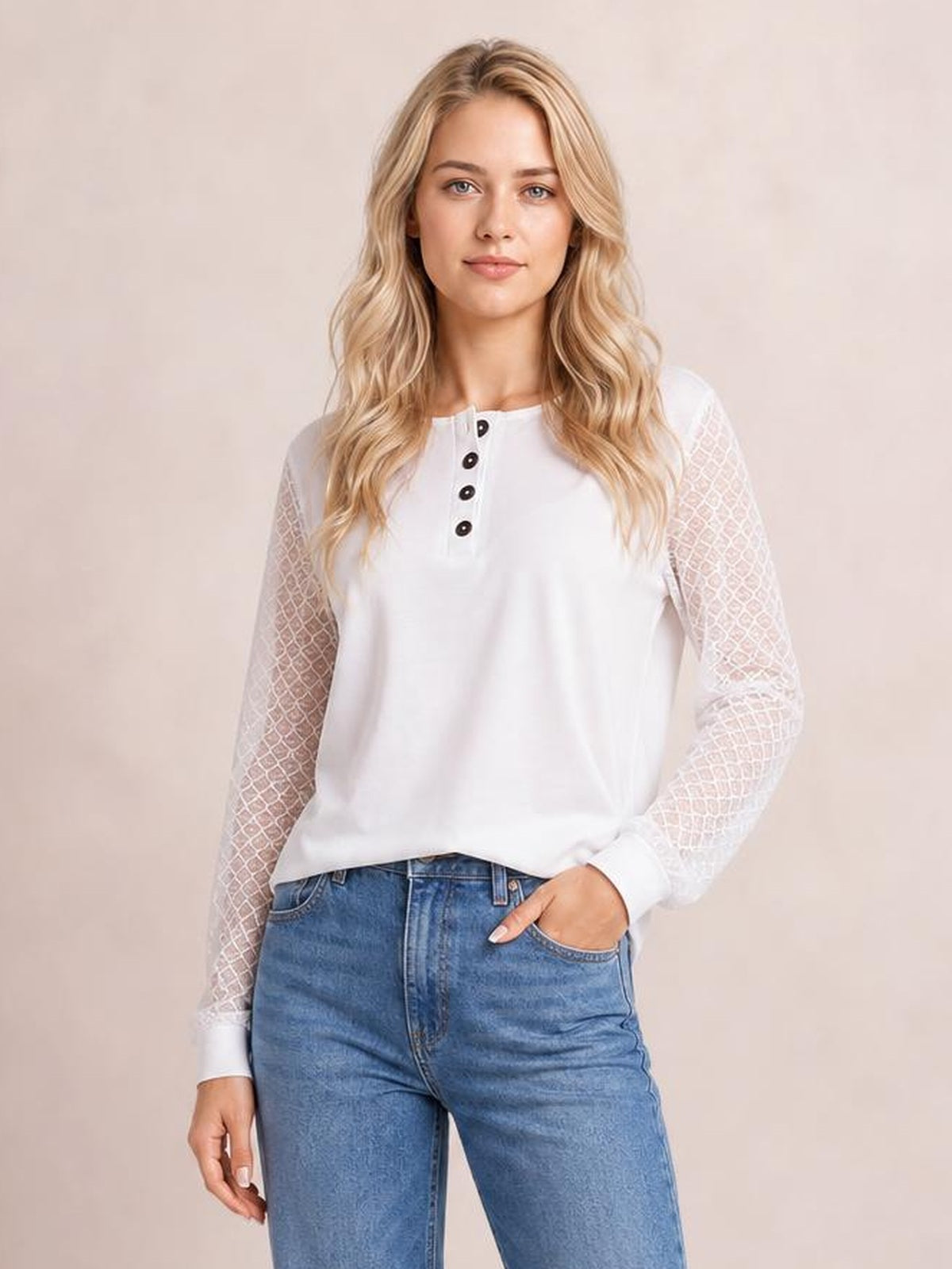 A model wears a white round-neck long-sleeve blouse with a quarter-button placket, semi-sheer lace-patterned sleeves, and a relaxed silhouette.