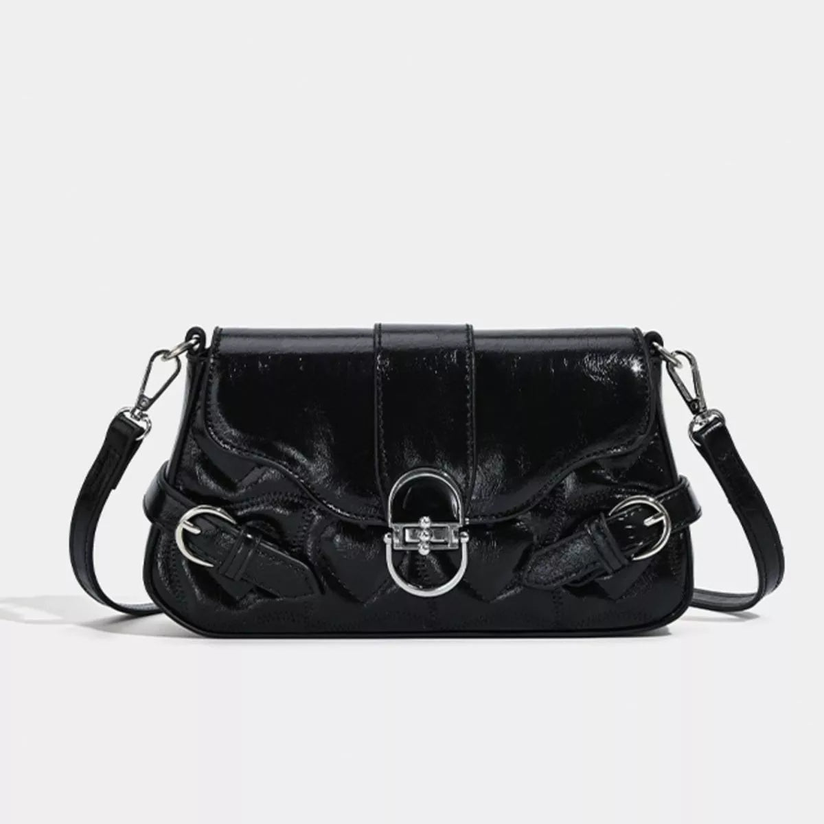 Small black PU leather crossbody bag with a structured silhouette, glossy finish, flap closure, central buckle, decorative side rings, and adjustable strap.