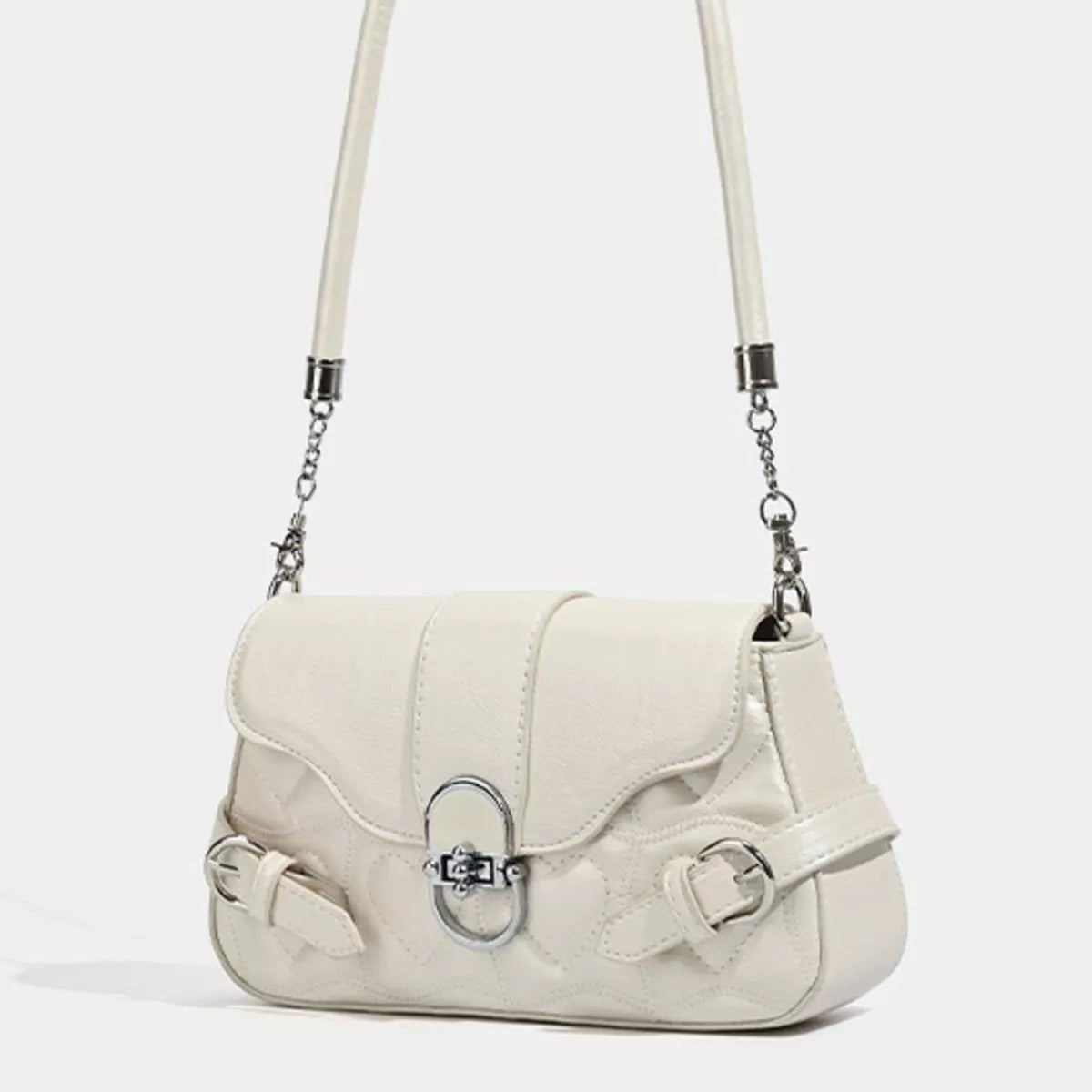Small cream PU leather crossbody bag with a flap closure, quilted texture, decorative buckle straps, silver-tone clasp, and a chain-linked shoulder strap.