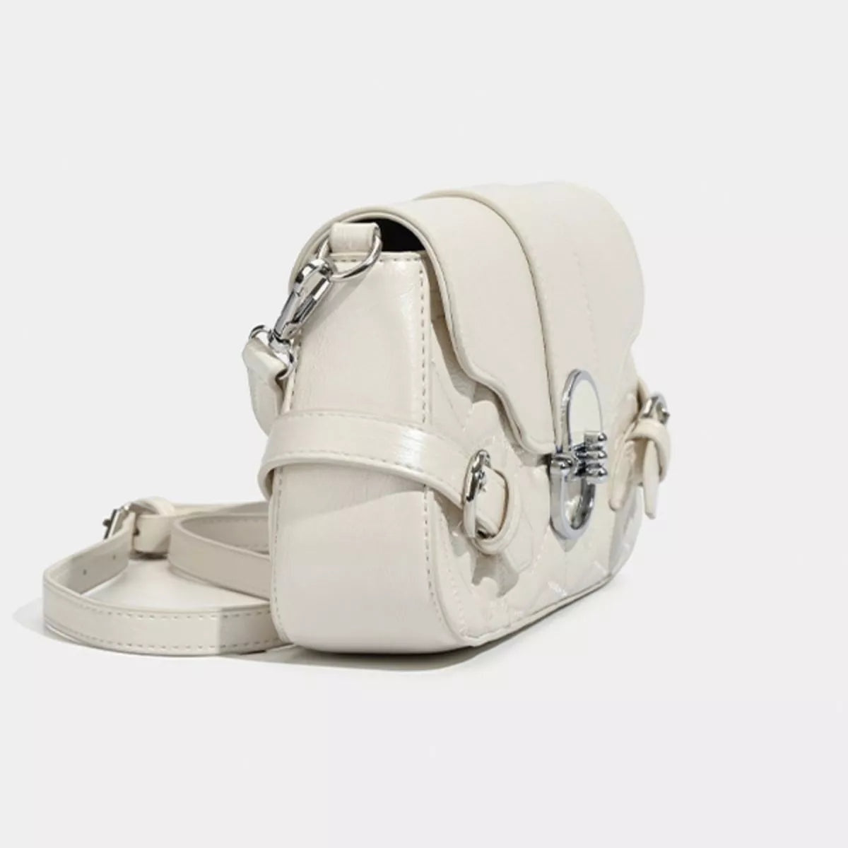 Small ivory PU leather crossbody bag with a structured silhouette, smooth flap, silver-tone buckle accents, and an adjustable strap.