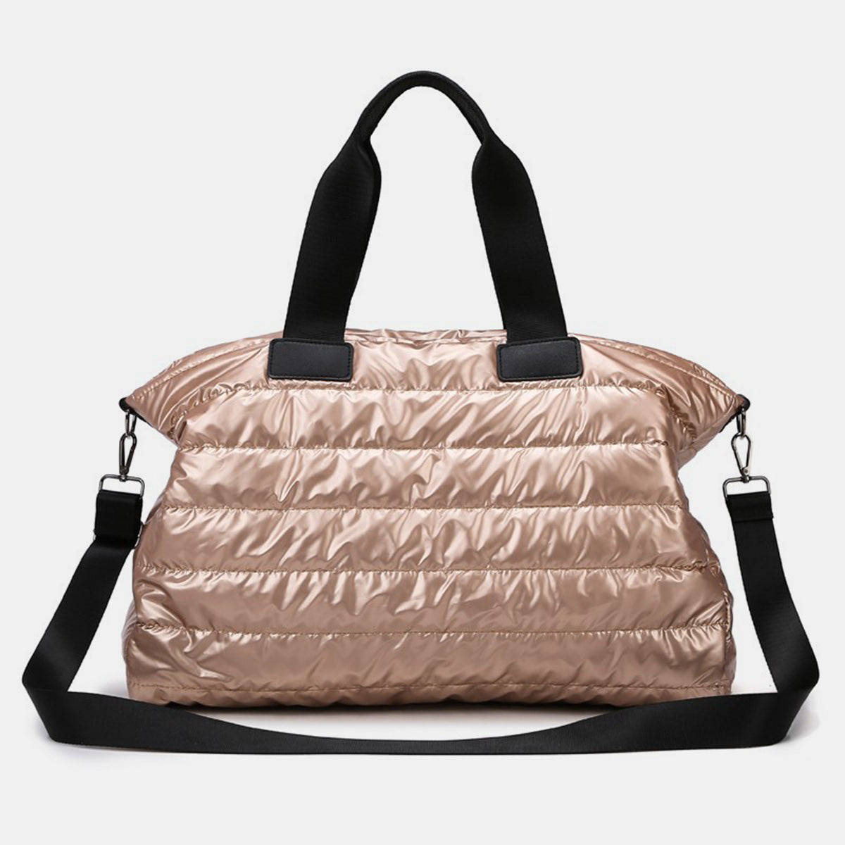 An oversize rose-gold quilted nylon travel bag features a softly padded silhouette, sturdy black top handles, and a detachable long shoulder strap.