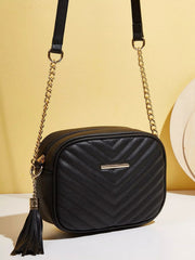 Black mini quilted PU leather crossbody bag with a rounded rectangular silhouette, gold-tone chain strap, and long tassel detail.