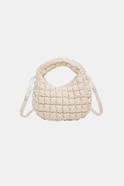 Cream quilted puffy crossbody bag with a rounded silhouette, gathered construction, padded top handle, and removable shoulder strap.