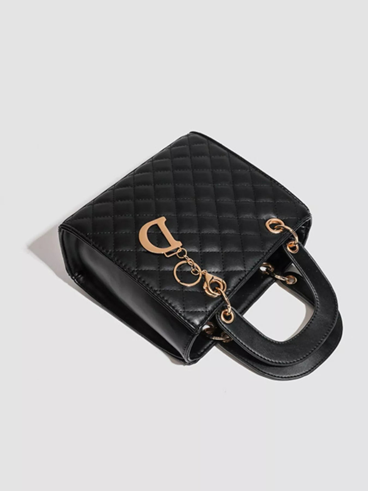 A mini black PU leather quilted handbag with a structured rectangular silhouette, top handle, and gold-tone hardware.
