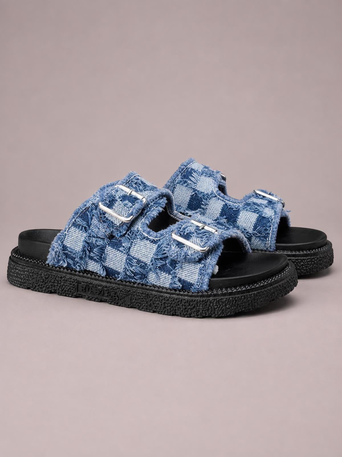 Blue checkered cloth buckle sandals feature frayed raw edges, two adjustable silver-tone straps, and thick black rubber flat soles.