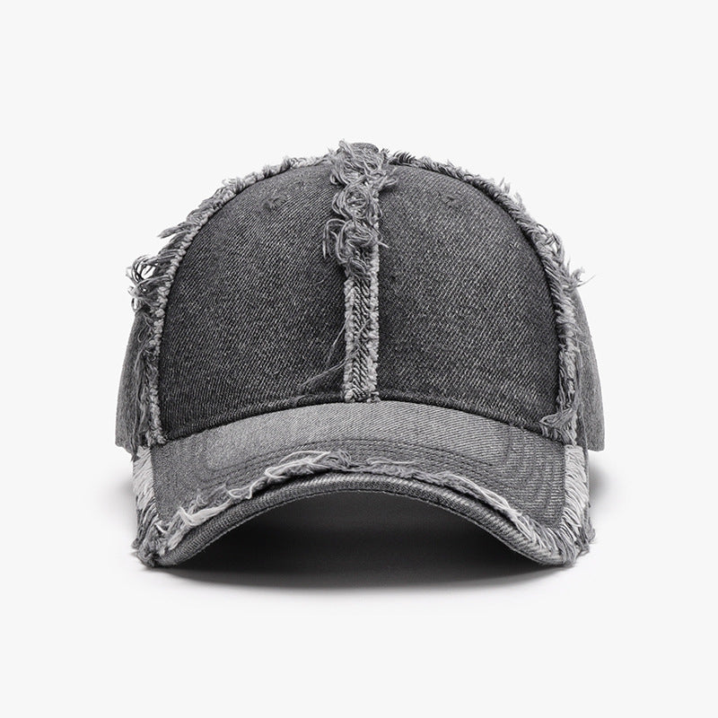 Gray cotton baseball cap with a relaxed six-panel crown, curved brim, tonal stitching, and distinctive raw frayed hems along the seams and edges.