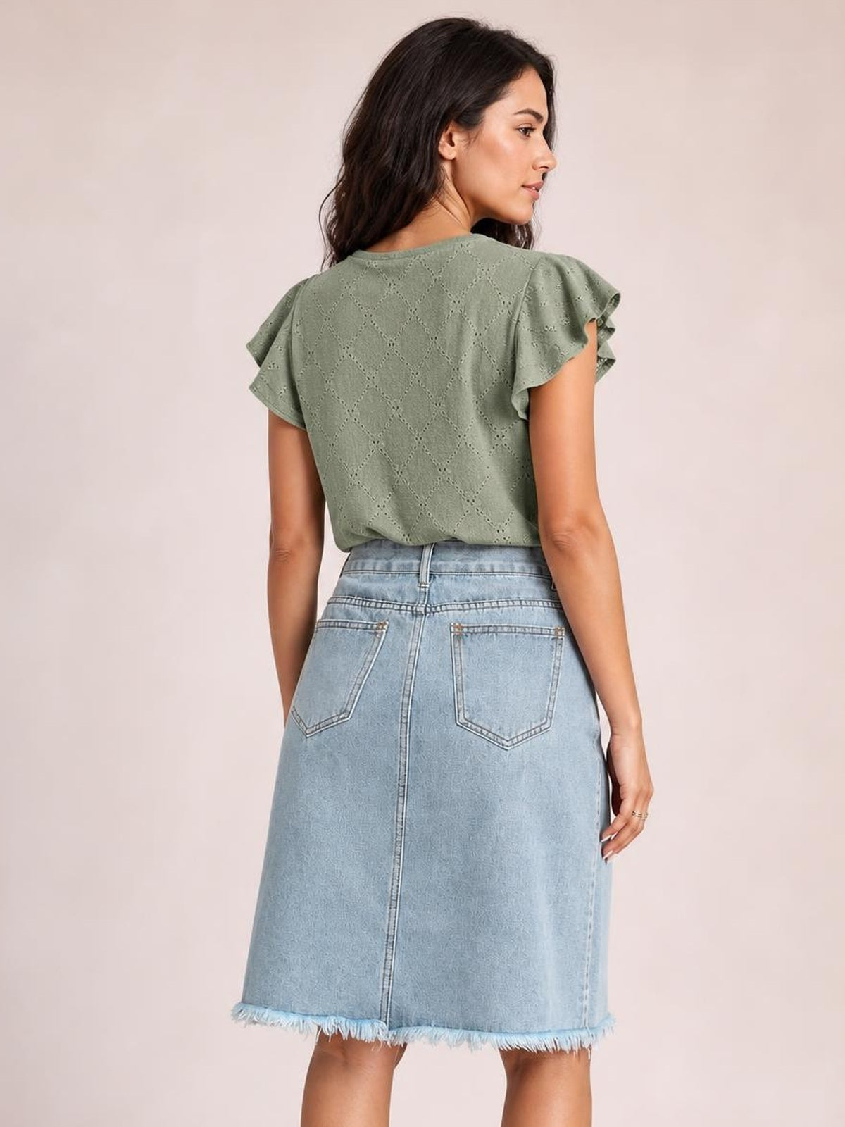 Model shown from behind wearing a light blue denim skirt with a straight midi silhouette, back patch pockets, center seam, and frayed raw hem.