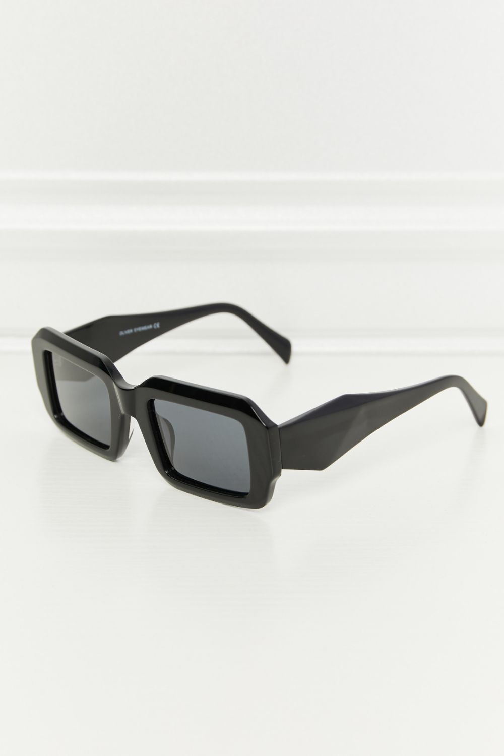 Black rectangular full-rim sunglasses feature sleek acetate frames, dark TAC polarized lenses, a softly squared silhouette, and bold wide temples.