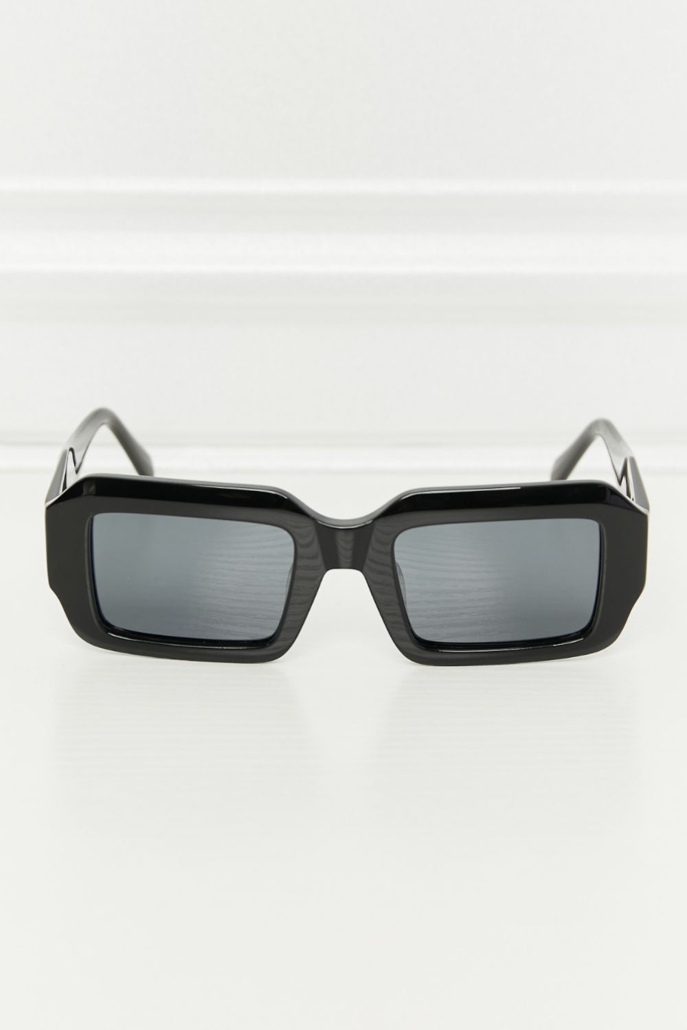 Black full-rim acetate sunglasses feature a bold rectangular silhouette, glossy frame, broad matching temples, and dark TAC polarized lenses.