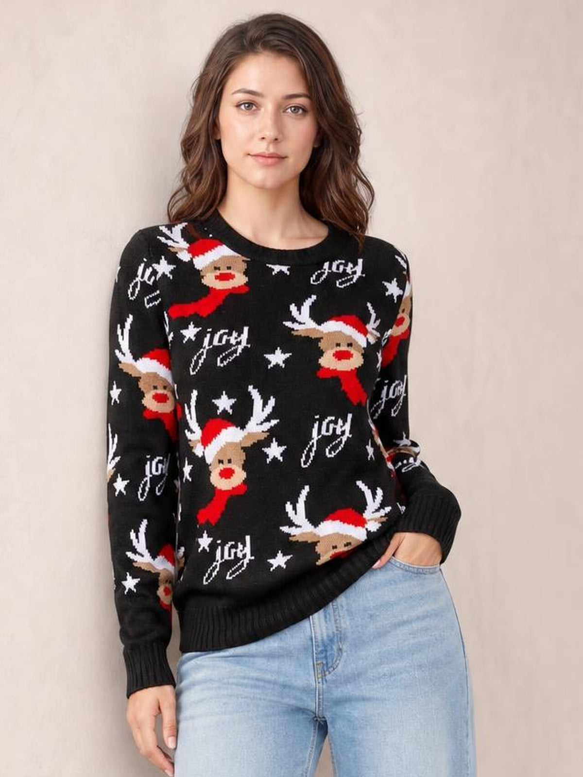 Model wearing a black reindeer round neck sweater with long sleeves, ribbed cuffs and hem, festive red and white motifs, and a relaxed silhouette.
