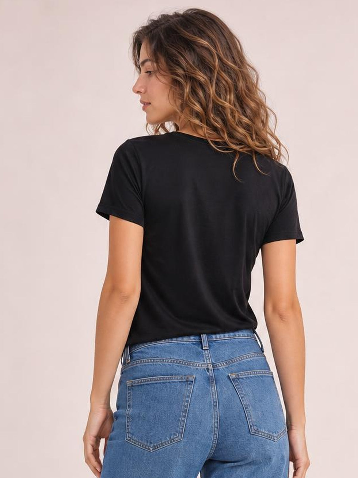 Model shown from the back wears a black round-neck short-sleeve T-shirt with an opaque, relaxed silhouette and smooth construction.