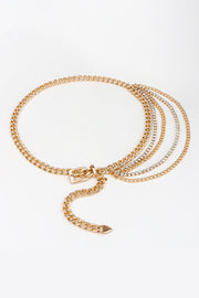 Gold rhinestone decor metal chain belt shown flat with layered chain strands, sparkling accents, a decorative buckle-style front, and a trailing chain extension.