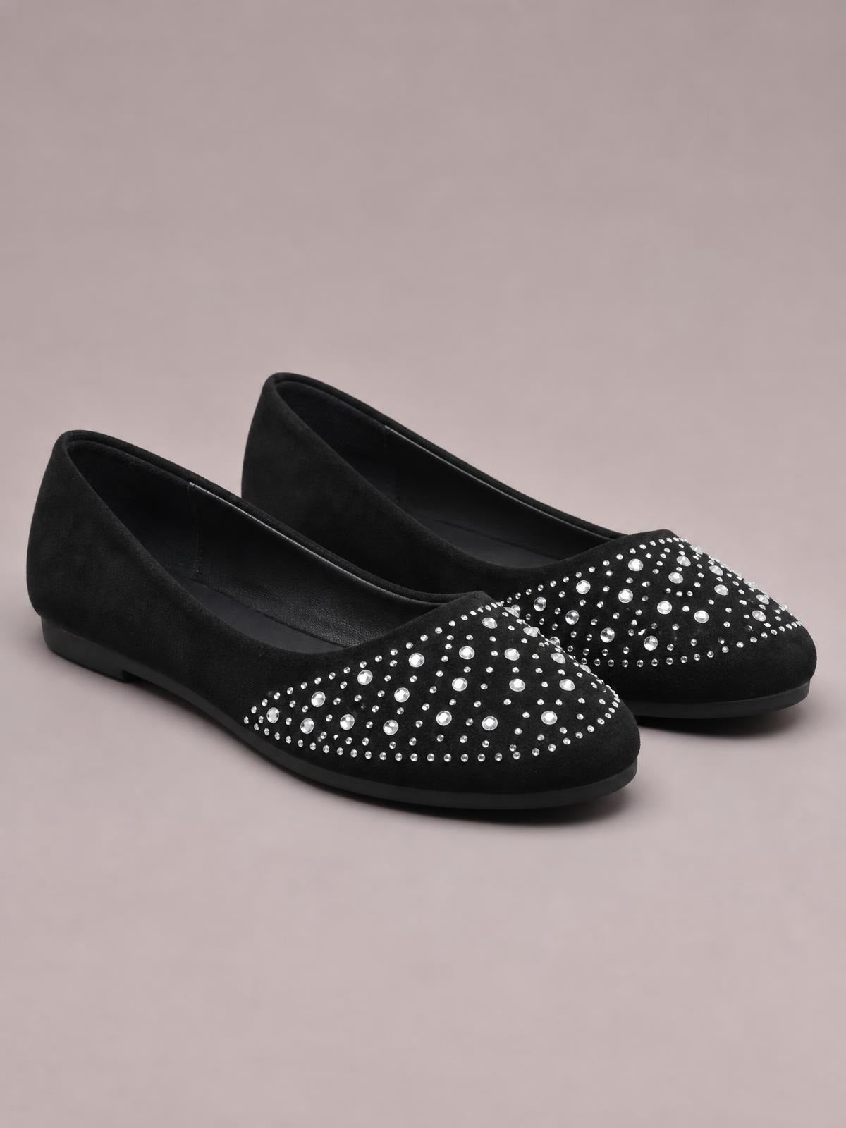 Black flat slip-on shoes with pointed toes, low wedge silhouettes, and silver rhinestone embellishments arranged across the vamp.