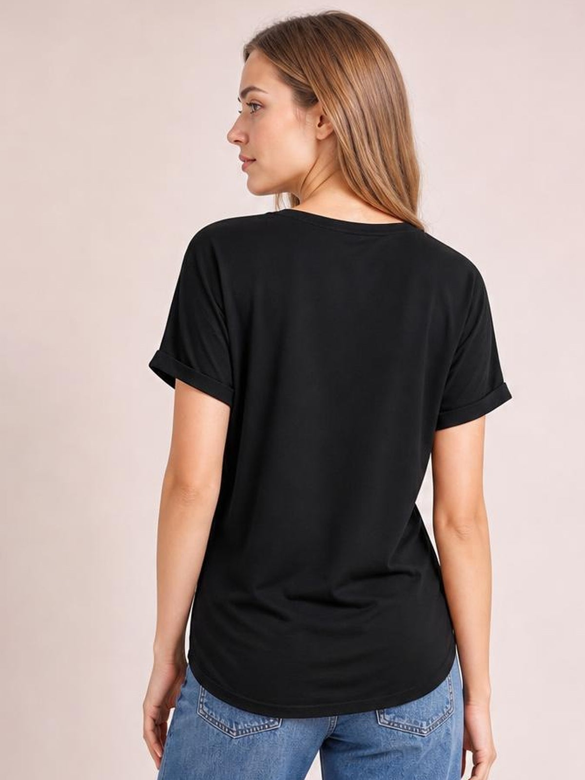 Woman shown from behind in a black round-neck short-sleeve T-shirt with rolled cuffs, relaxed fit, curved hem, and slightly stretchy silhouette.