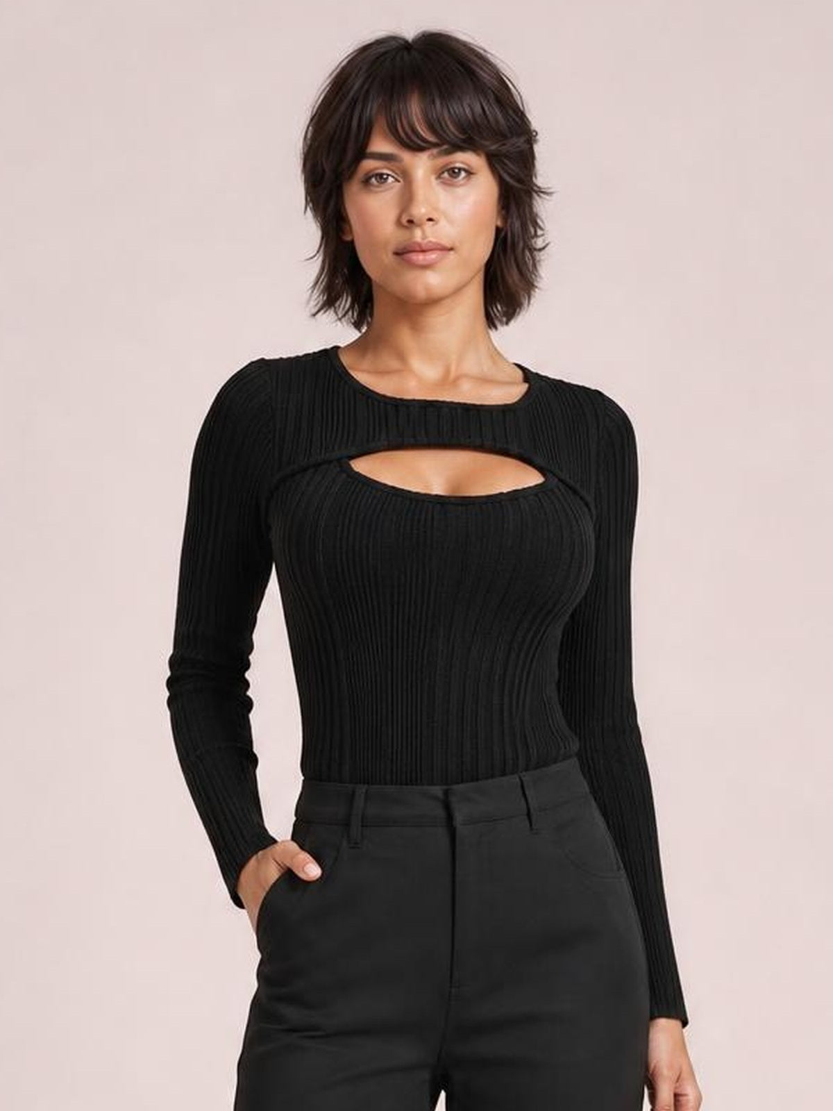 Model poses in a black ribbed cutout round-neck bodysuit with long sleeves, a fitted silhouette, and a horizontal chest cutout.