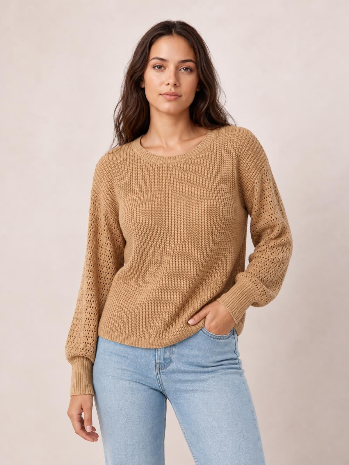 Model wearing a tan ribbed round neck pullover sweater with long dropped-shoulder sleeves featuring openwork detailing and a regular silhouette.