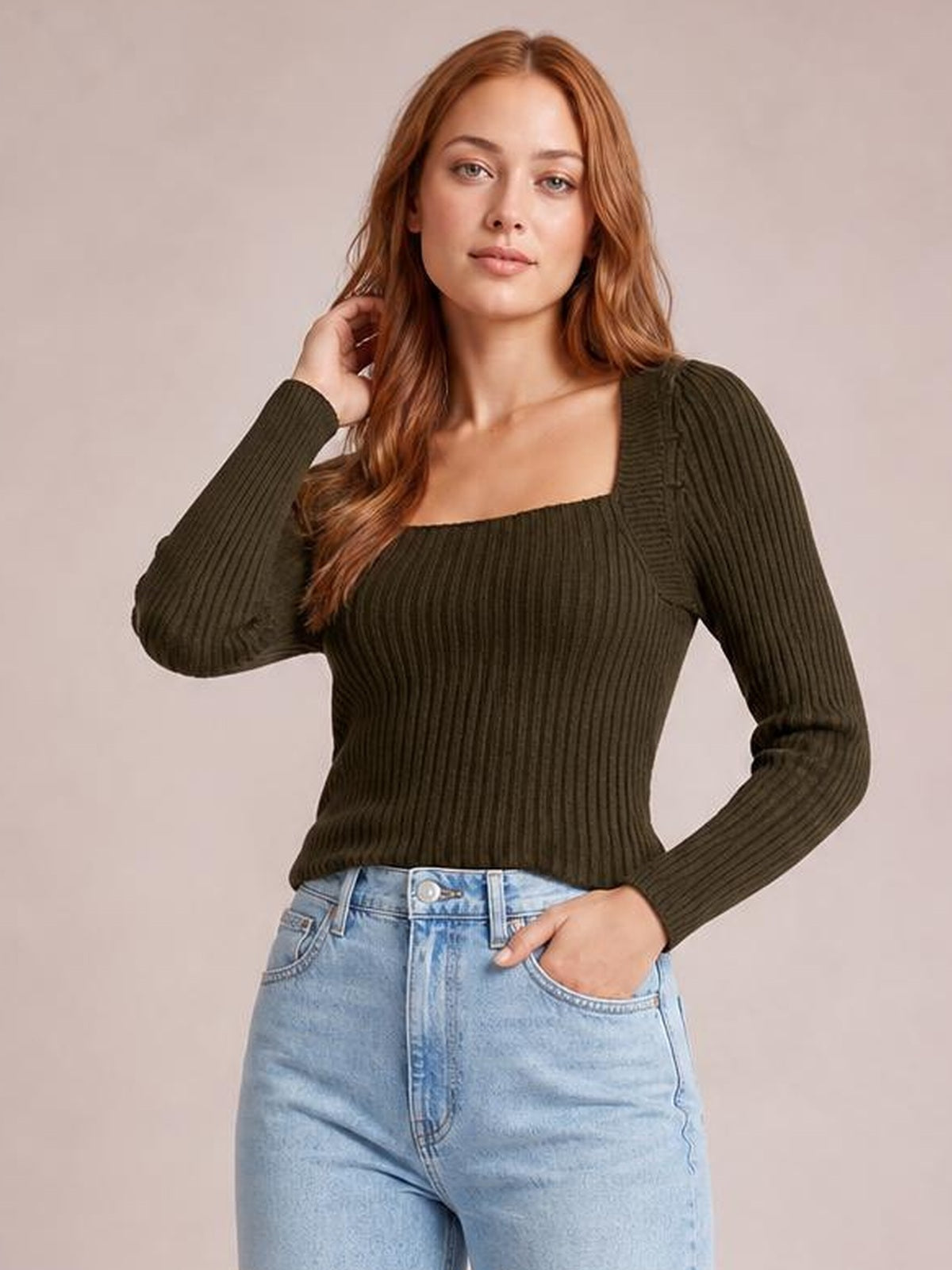 Model poses in a fitted dark olive ribbed sweater with a square neckline, long sleeves, and a waist-length silhouette.