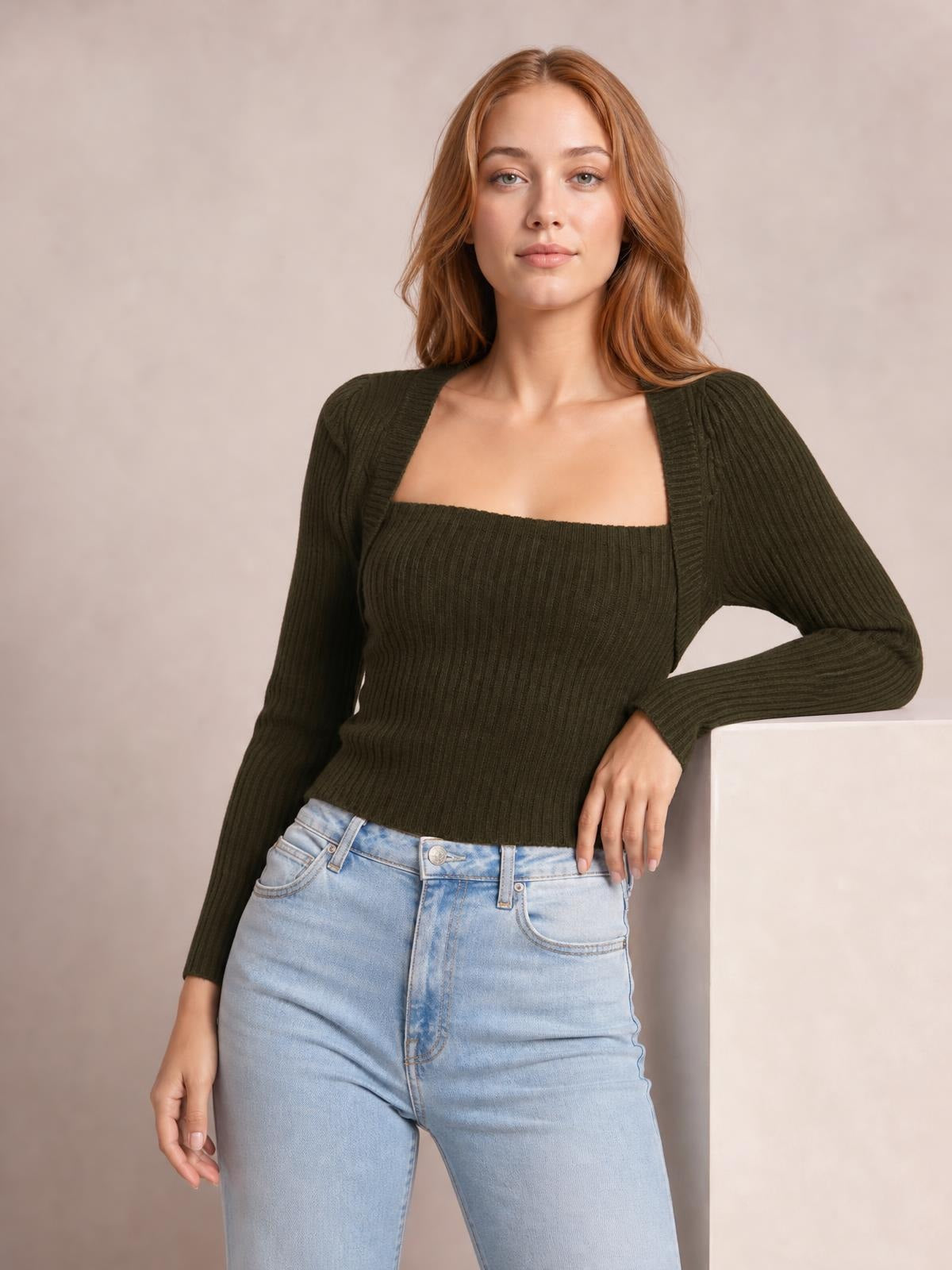 A model poses in a dark olive ribbed square neck sweater with a fitted silhouette, long sleeves, and a stretchy knit construction.
