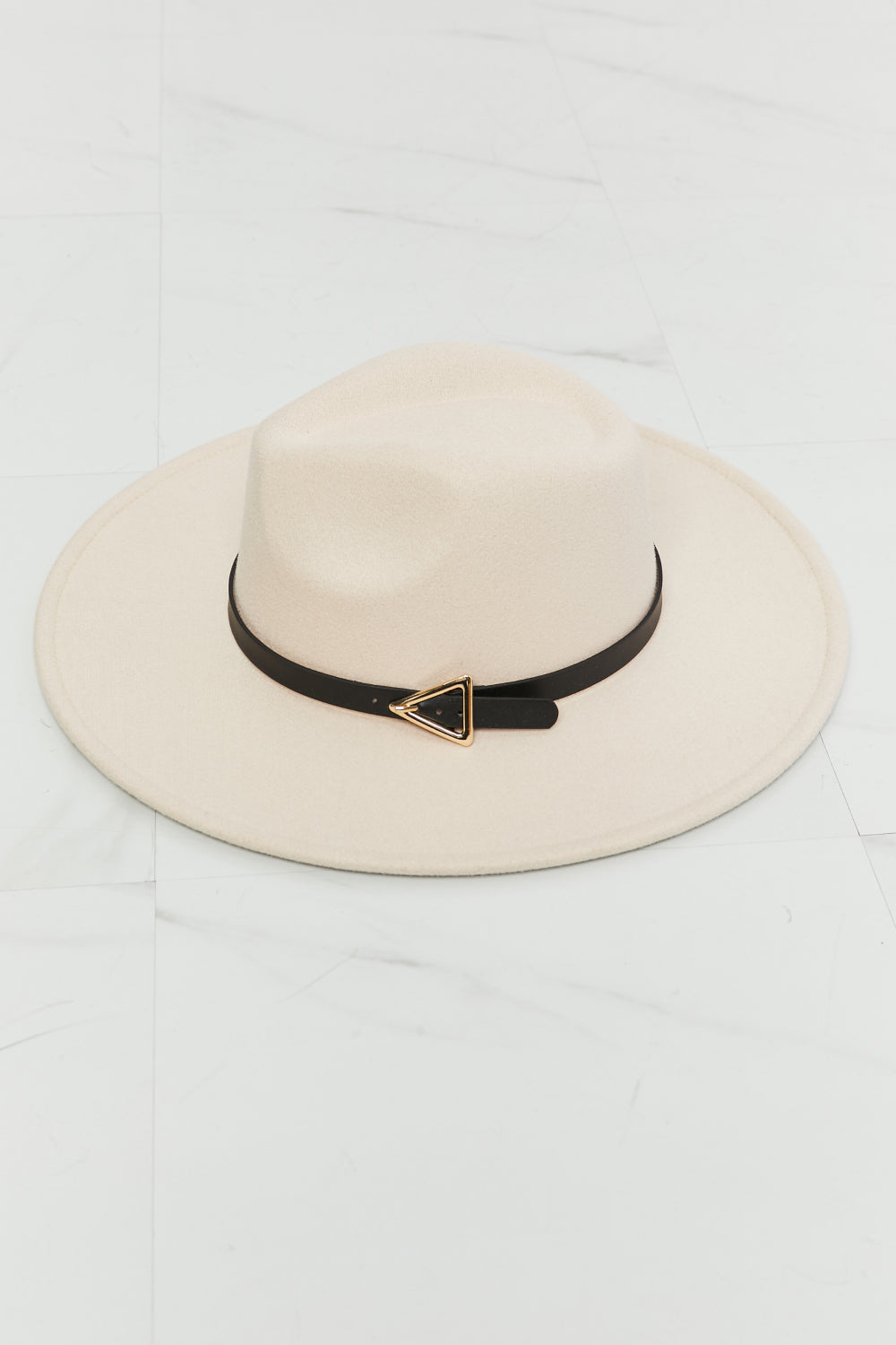 Soft beige Ride Along fedora hat with a structured crown, wide brim, black contrast belt, and distinctive triangle-shaped gold buckle.
