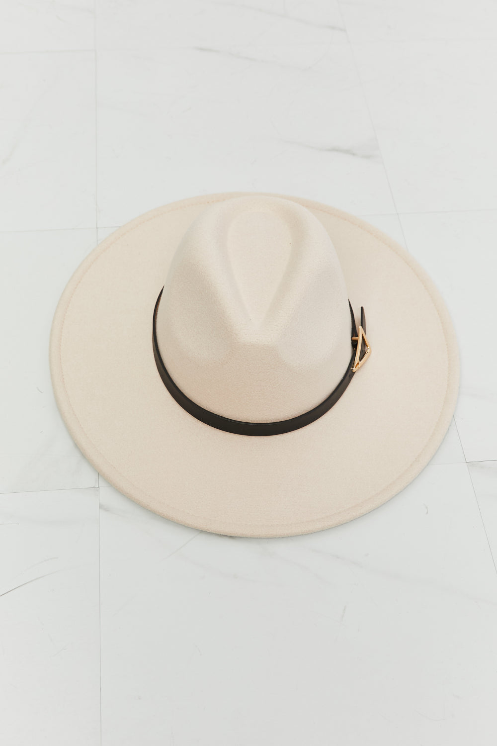 Soft beige Ride Along fedora hat with a structured crown, wide 3.5-inch brim, black contrast band, and triangle-shaped gold buckle.