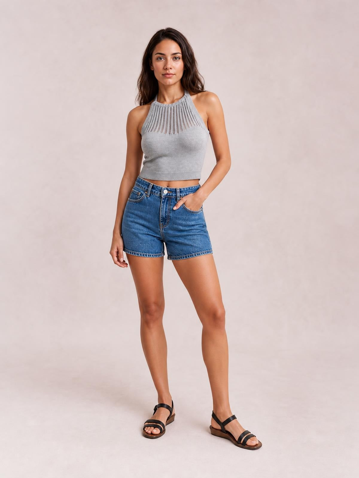 Model poses in blue denim slouchy shorts with a double-button waist, belt loops, front pockets, relaxed fit, and cuffed hem.