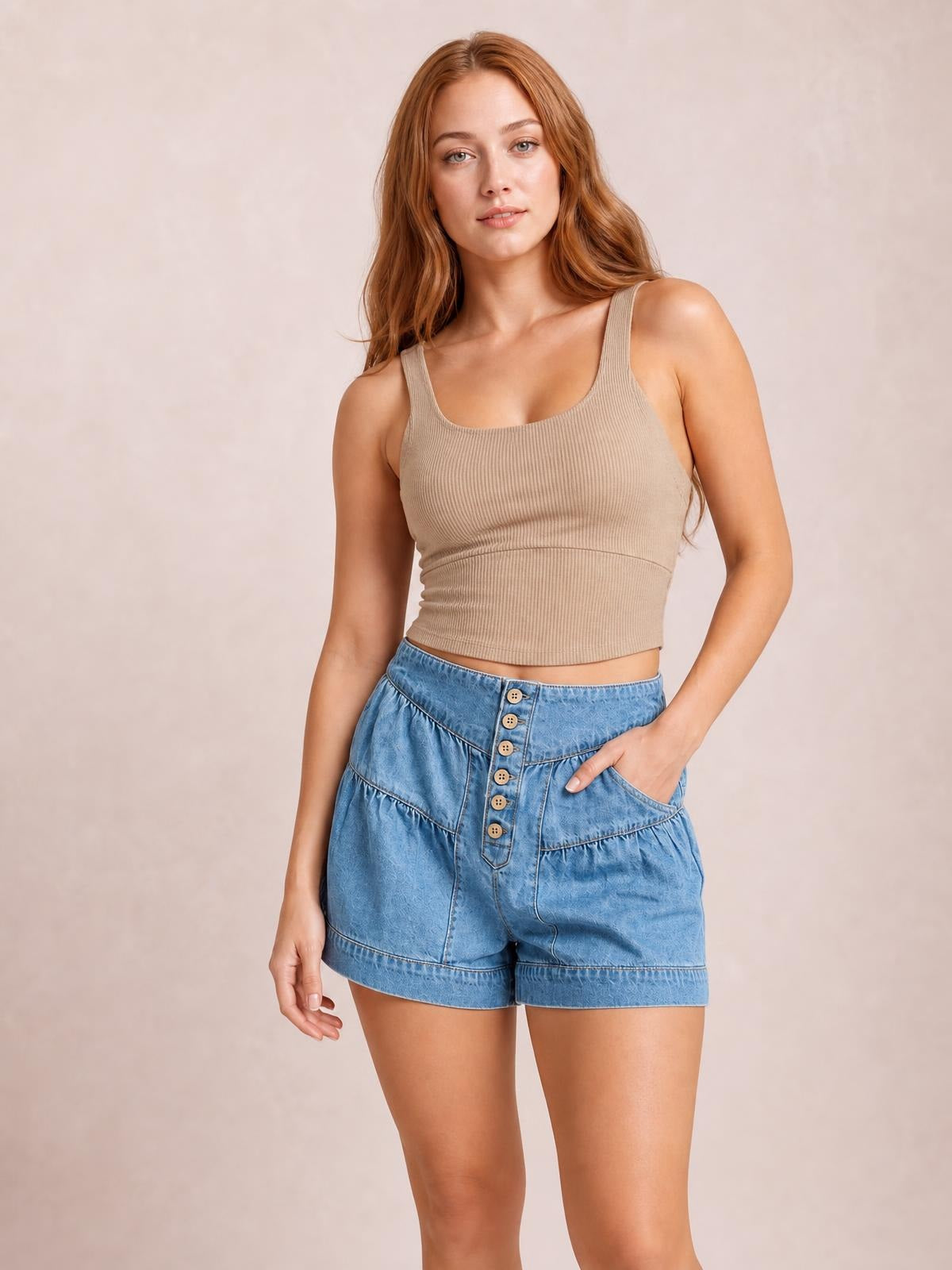 A model poses with one hand in the pocket, wearing light blue slouchy shorts with an elastic waistband, button fly, gathered shirred details, and cuffed hems.
