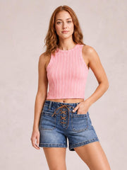 Model poses in relaxed blue denim high-rise shorts with a front lace-up tie, patch pockets, contrast stitching, and a straight relaxed leg silhouette.