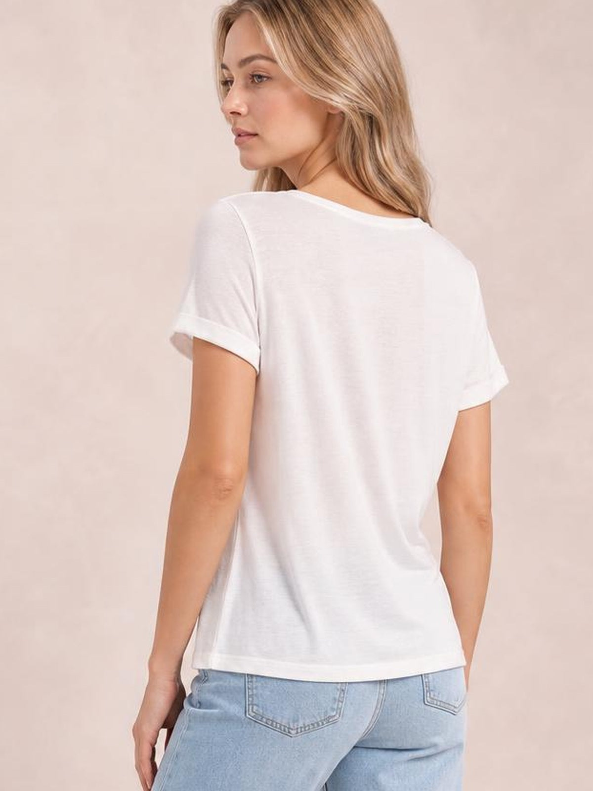 A model looks over her shoulder wearing a white round-neck short-sleeve T-shirt with rolled cuffs and a relaxed, straight silhouette.