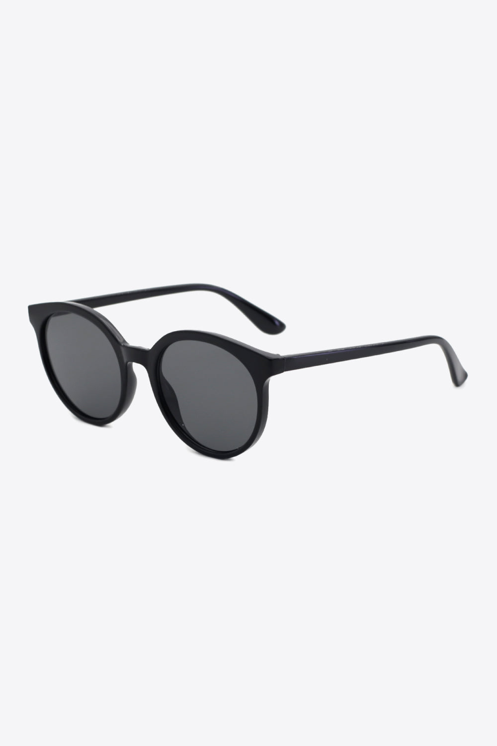 Black round full-rim sunglasses feature a softly curved polycarbonate frame, dark acetate lenses, and slim temples shown at an angled view.