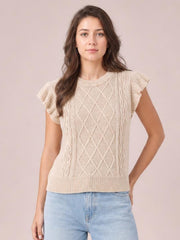 Model wearing a cream round-neck cap-sleeve sweater with ruffled shoulders, cable-knit diamond detailing, ribbed trim, and a straight silhouette.