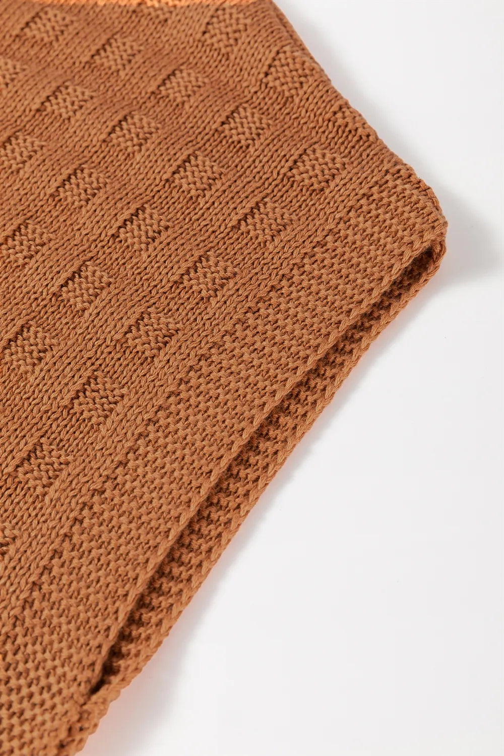 Close-up of the brown round neck cap sleeve sweater vest showing its textured knit construction, raised geometric pattern, and neatly finished edge.