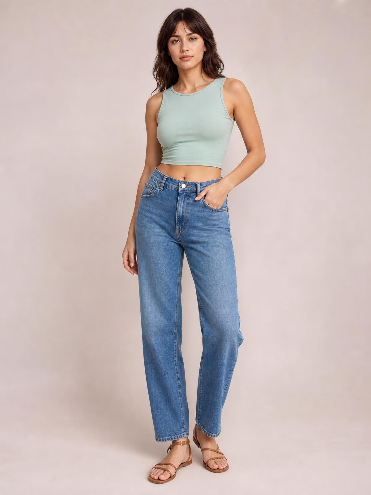 Model wearing a mint green round neck cropped tank with a stretchy, fitted silhouette, wide shoulder straps, and a clean basic construction.