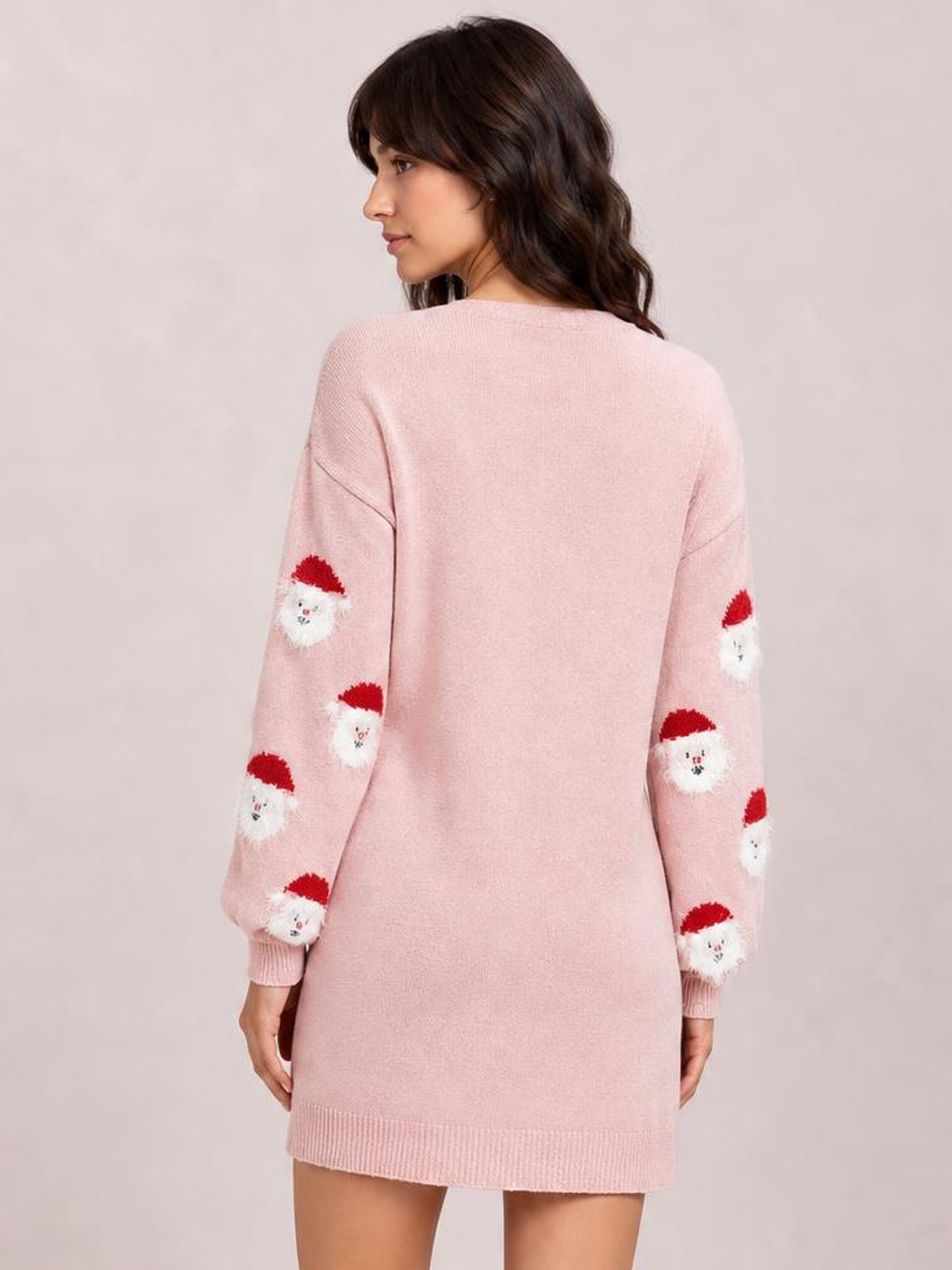 Back view of a pink round-neck sweater dress with dropped shoulders, relaxed straight silhouette, long sleeves, Santa face motifs, and ribbed cuffs and hem.
