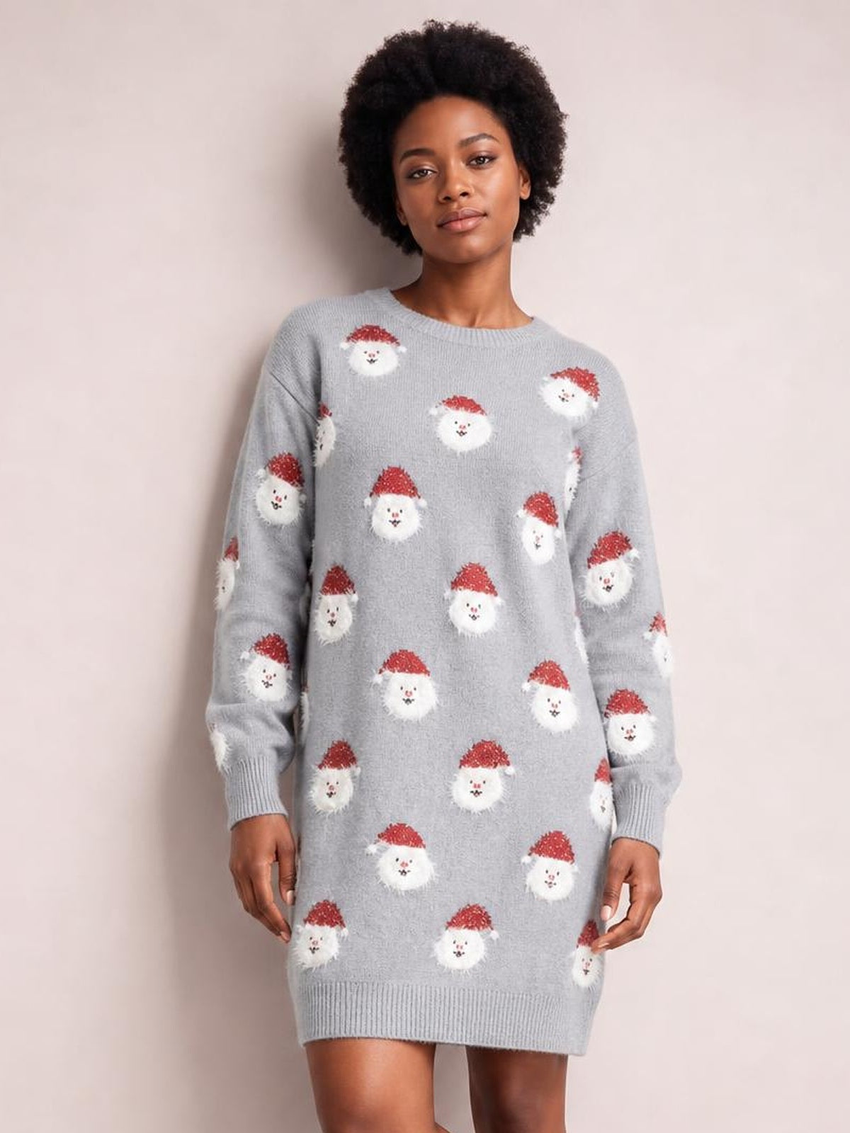 Model wears a light gray round neck dropped shoulder sweater dress with a relaxed silhouette, long sleeves, ribbed cuffs and hem, and Santa face pattern.